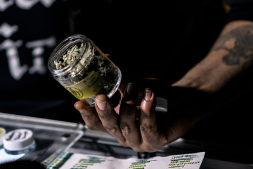 Man holding THCV cannabis jar