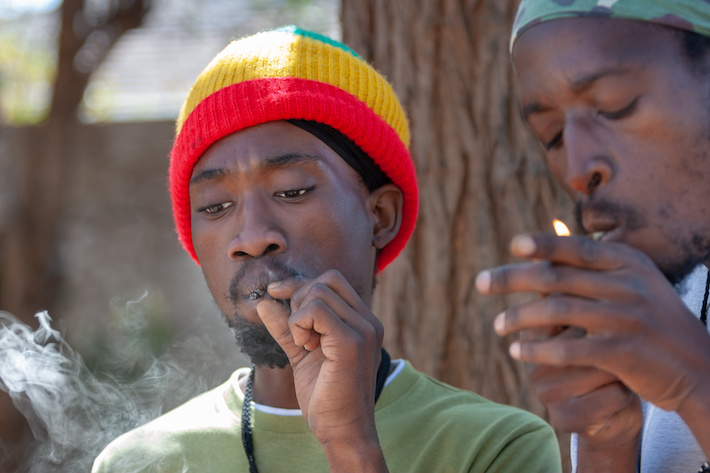African rastafarian men smoking marijuana