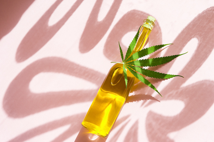 CBD oil in a bottle with marijuana leaf