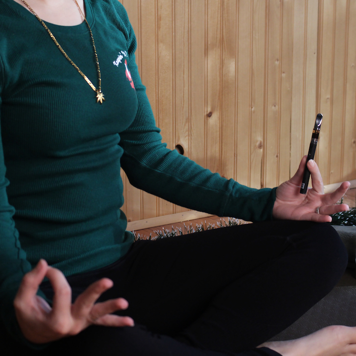 Marijuana user meditating while holding a cannabis vape pen