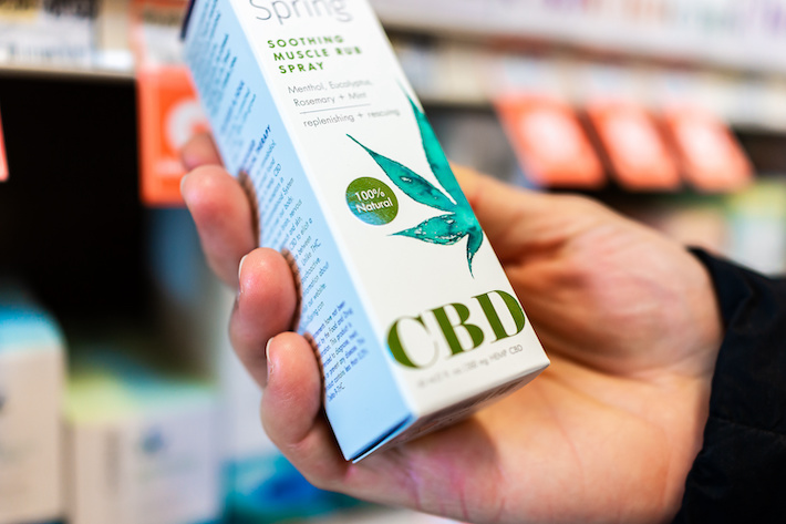 Person holding a CBD oil product at a store