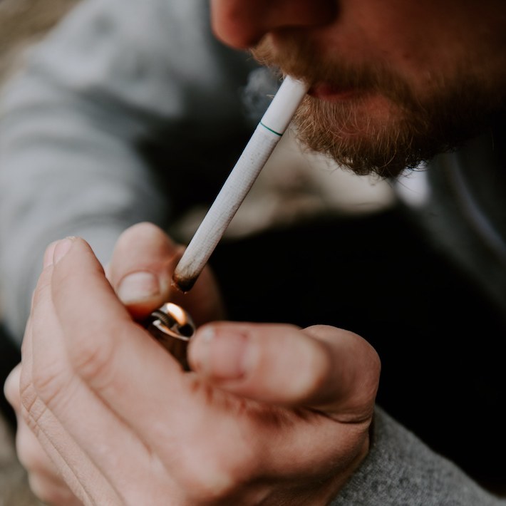 Man lighting and smoking a CBD cigarette