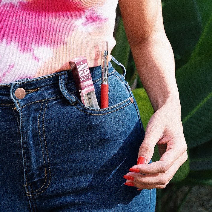 Woman carrying delta-8 cartridge and vape pen in pocket
