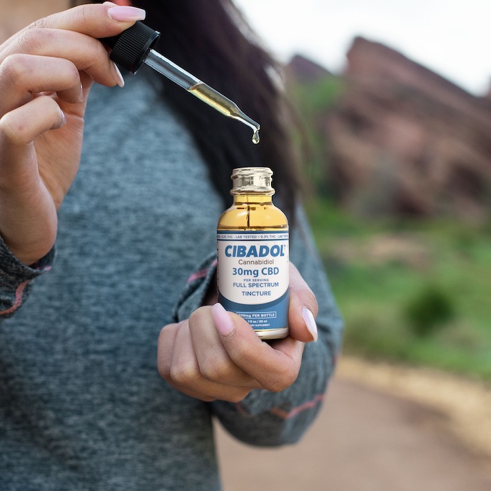 Woman holding an affordable CBD tincture product