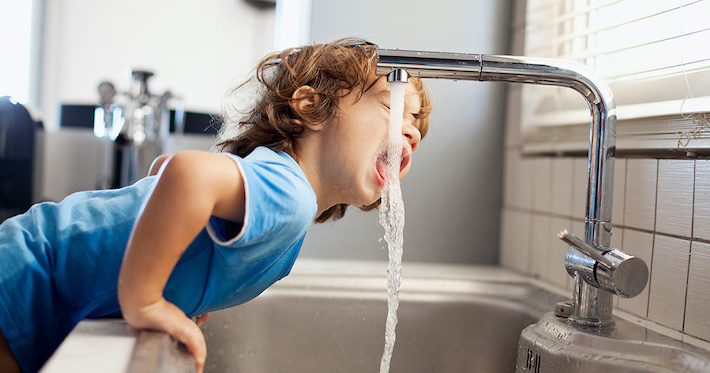 Boy drinking water from the tap