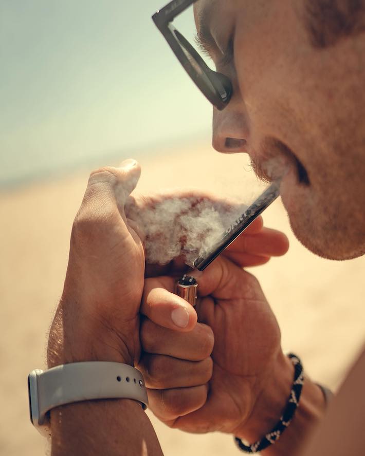 Man smoking a one-hitter pipe outside