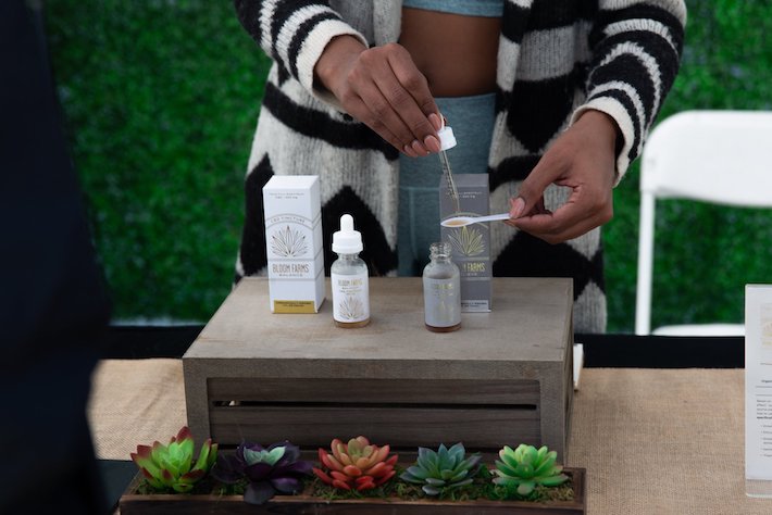 Woman is testing the quality of various CBD oil and tincture products at a booth