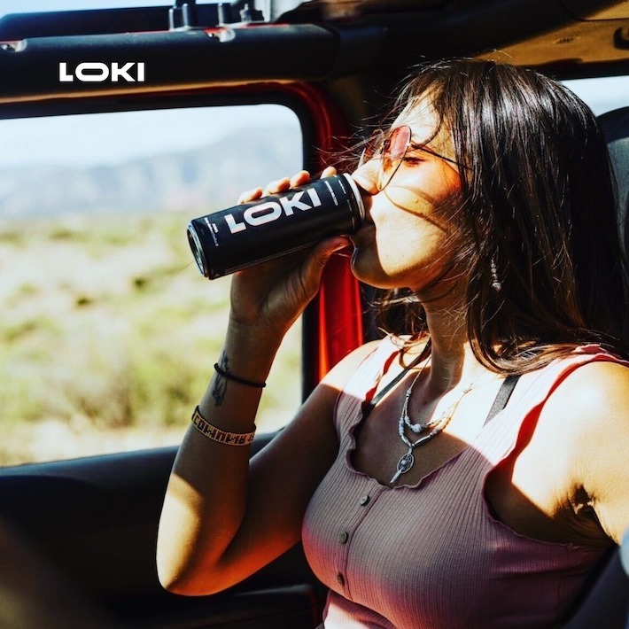 Woman having fun drinking delta-8 THC seltzer beverage in the car