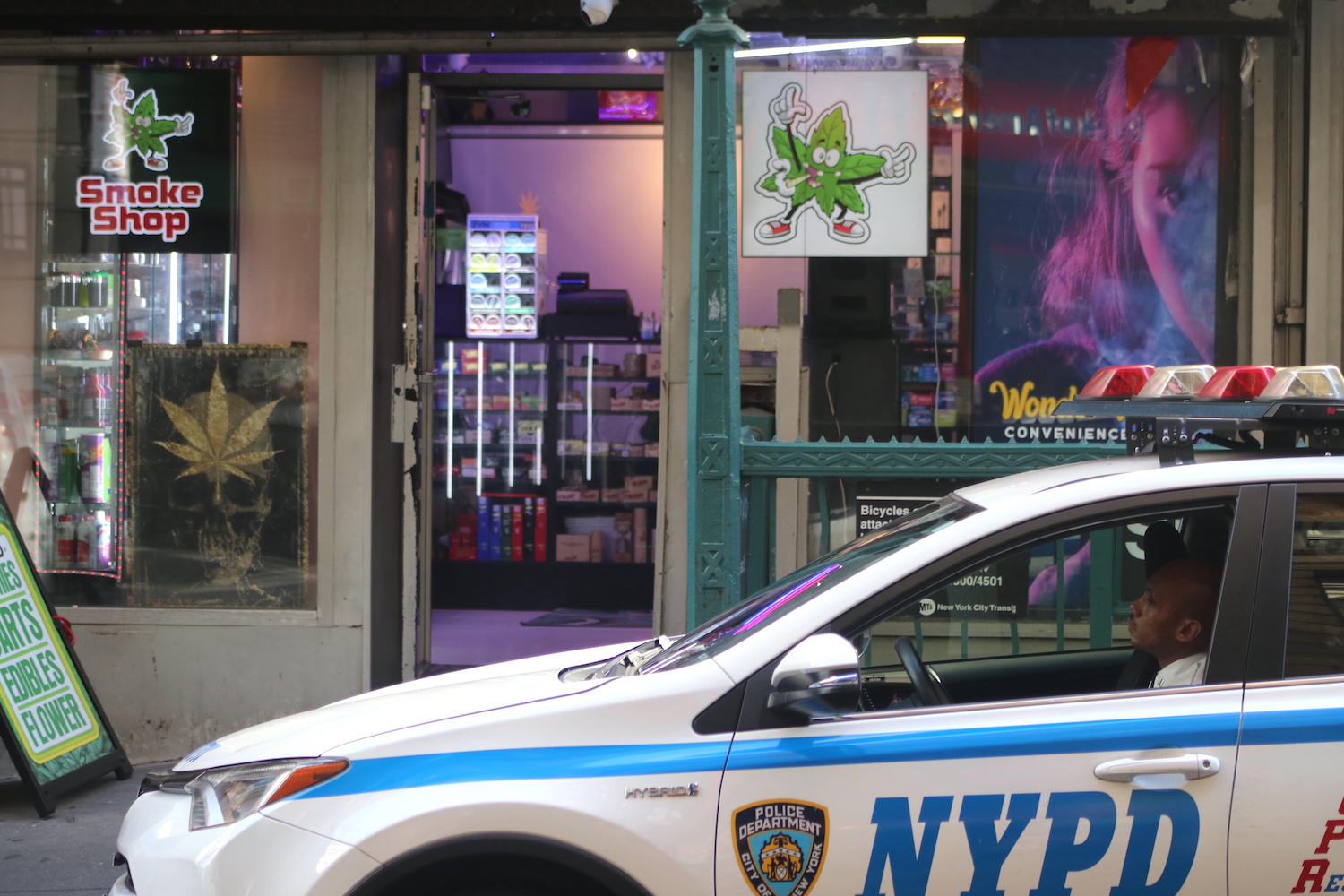 NYPD police car parked front of a cannabis store in New York