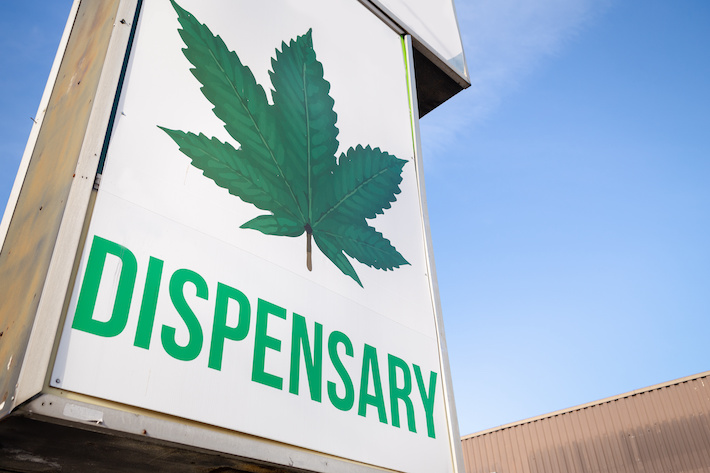 Cannabis dispensary sign with a large marijuana leaf