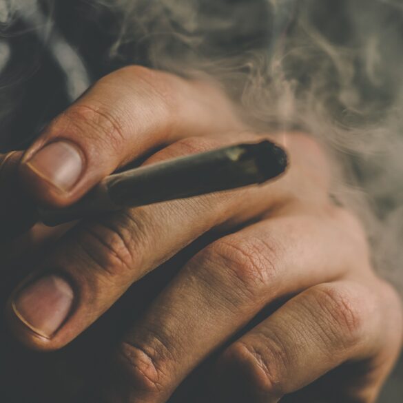 Man smoking a cannabis joint with big clouds of smoke